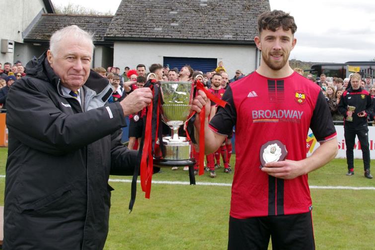 Clarbeston Road skipper receives Rheinallt George Senior Cup from Mike Johns of the Pembrokeshire Football League Council 